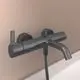 Wandmontierte Armatur in mattschwarz mit einem Auslauf und einem Hebel zum Regulieren des Wasserflusses. Ideal Standard.